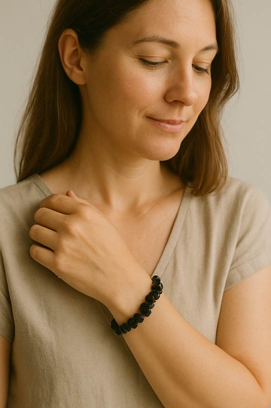 Femme portant un bracelet baroque noir en pierre naturelle au poignet droit